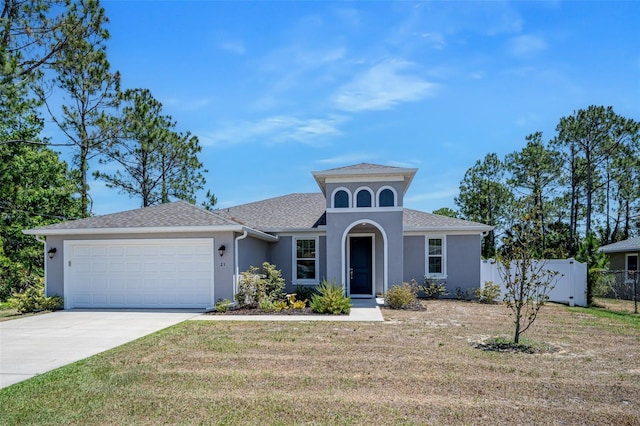 mediterranean / spanish-style house featuring fence, an attached garage, concrete driveway, stucco siding, and a front yard