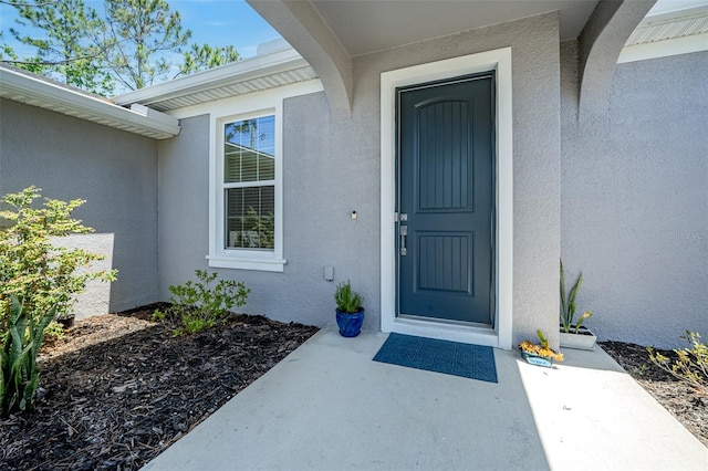 view of exterior entry featuring stucco siding