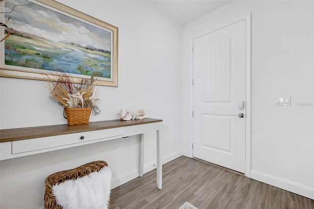 doorway with baseboards and light wood-style floors