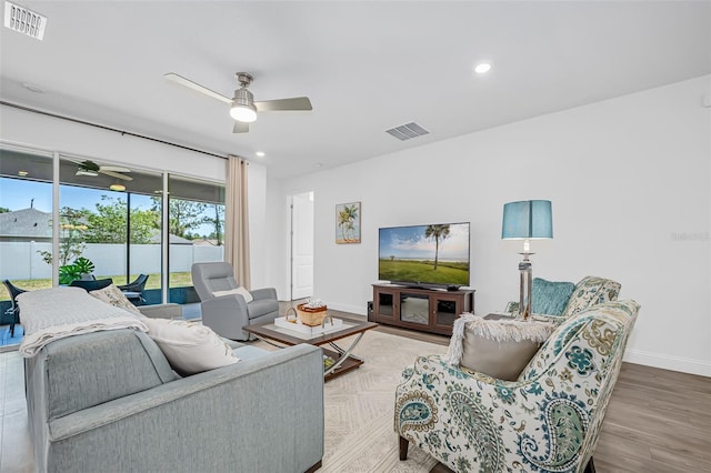living room featuring visible vents, baseboards, and ceiling fan