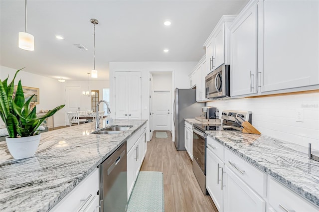 kitchen with visible vents, a sink, white cabinetry, stainless steel appliances, and light wood-type flooring