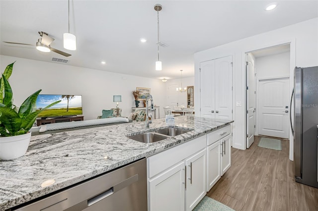 kitchen with visible vents, a sink, light wood-style floors, stainless steel appliances, and white cabinets