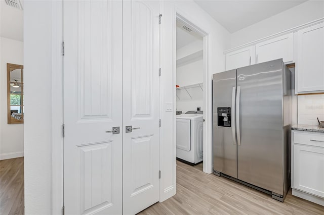 kitchen featuring white cabinetry, light wood-style flooring, stainless steel refrigerator with ice dispenser, and tasteful backsplash