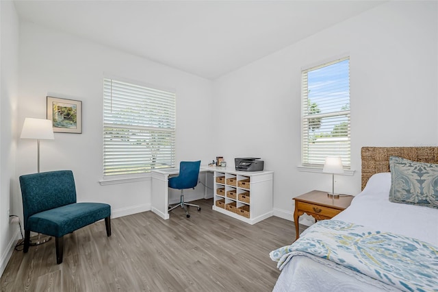 bedroom with wood finished floors and baseboards