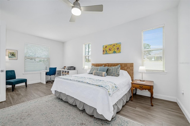 bedroom featuring light wood finished floors, baseboards, and a ceiling fan