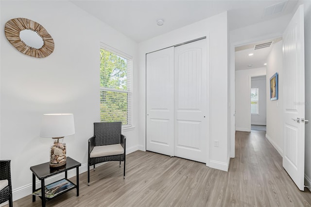 living area with light wood-style floors, visible vents, baseboards, and recessed lighting