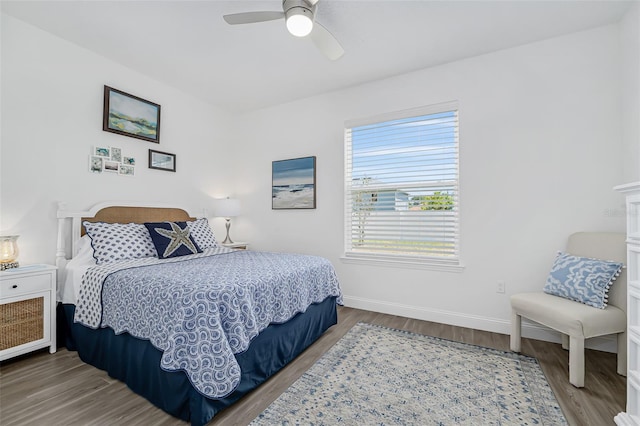 bedroom with ceiling fan, baseboards, and wood finished floors