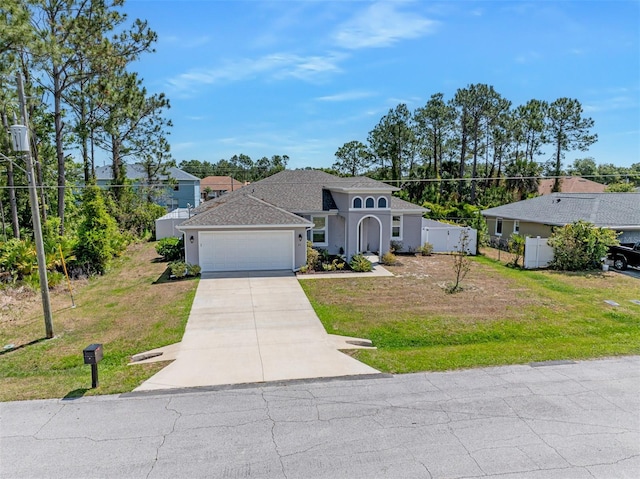 single story home with a front yard, a garage, fence, and driveway