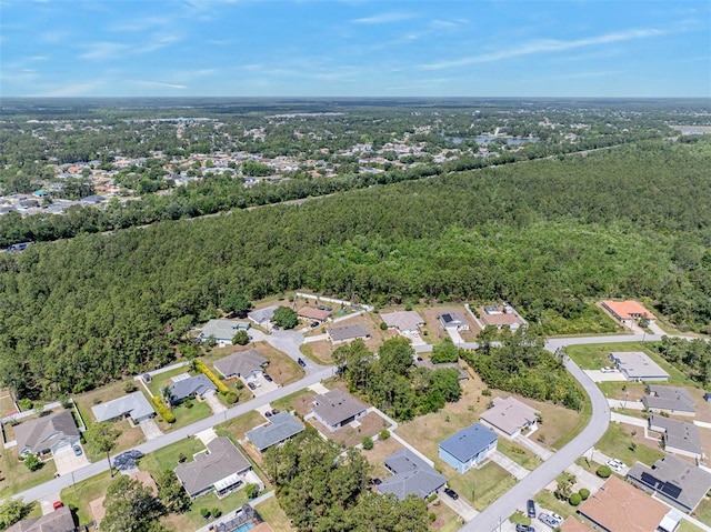 drone / aerial view featuring a residential view and a view of trees