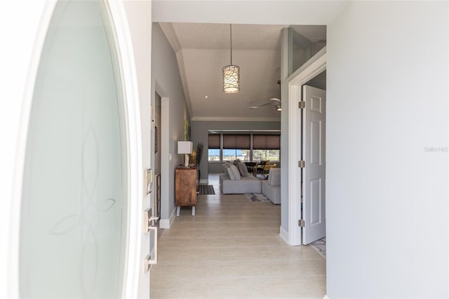 foyer with baseboards and ornamental molding
