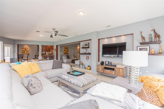 living area featuring a ceiling fan and visible vents