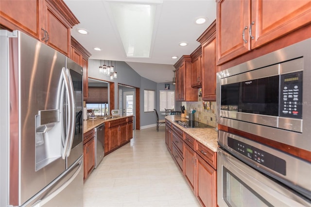 kitchen featuring stainless steel appliances, light stone counters, recessed lighting, and tasteful backsplash