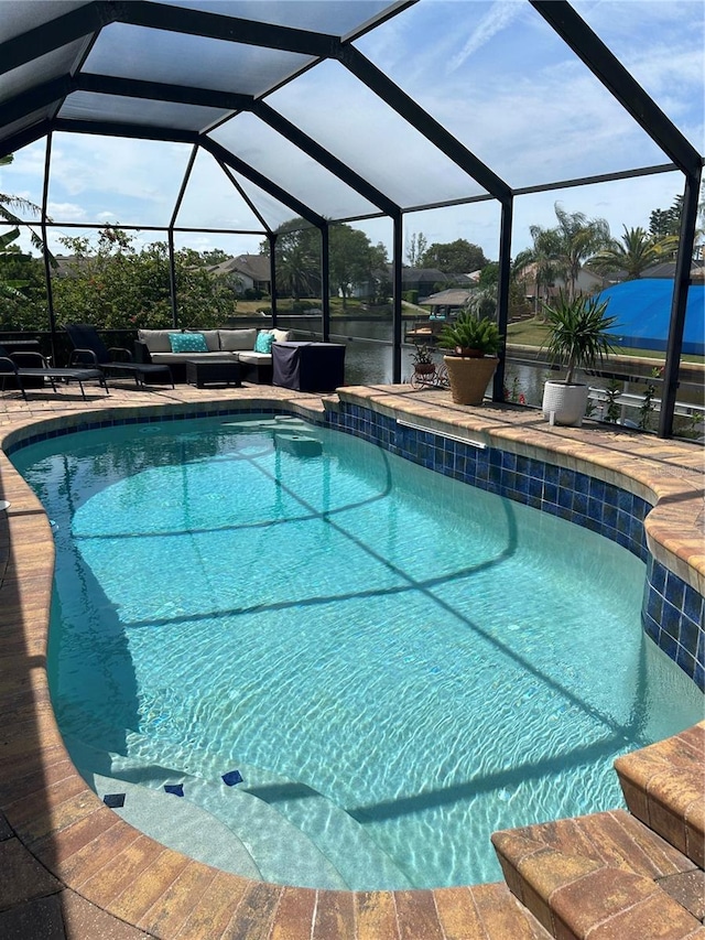 pool featuring an outdoor hangout area, glass enclosure, and a patio area