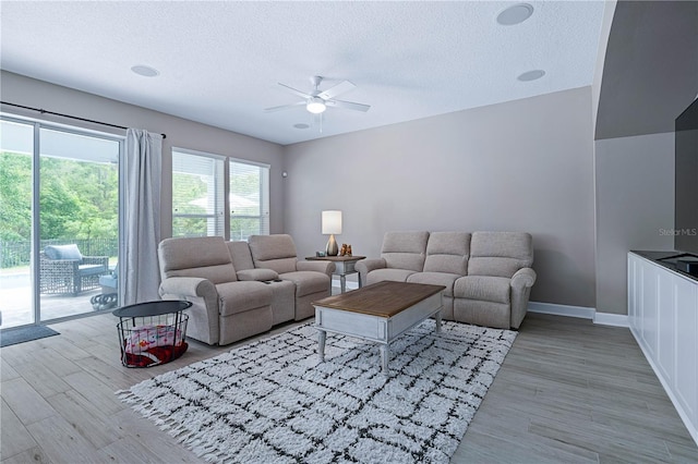 living area featuring a textured ceiling, ceiling fan, and wood finished floors