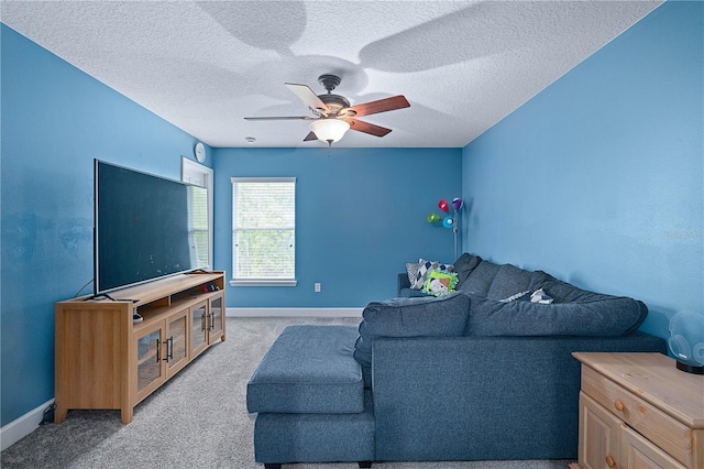 living area with a ceiling fan, baseboards, light carpet, and a textured ceiling