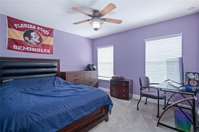 carpeted bedroom featuring baseboards and a ceiling fan