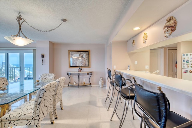 2937 S Atlantic Ave Unit 2001, Daytona Beach, FL 32118 - dining area featuring a textured ceiling, light tile patterned flooring, baseboards, and recessed lighting