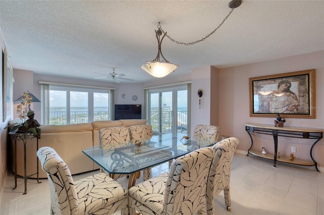 2937 S Atlantic Ave Unit 2001, Daytona Beach, FL 32118 - dining area featuring a textured ceiling, baseboards, light tile patterned floors, and ceiling fan
