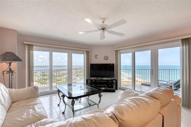 2937 S Atlantic Ave Unit 2001, Daytona Beach, FL 32118 - living area featuring light tile patterned floors, a textured ceiling, ceiling fan, and plenty of natural light