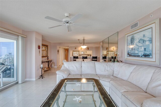 2937 S Atlantic Ave Unit 2001, Daytona Beach, FL 32118 - living area featuring a ceiling fan, a textured ceiling, light tile patterned floors, baseboards, and visible vents