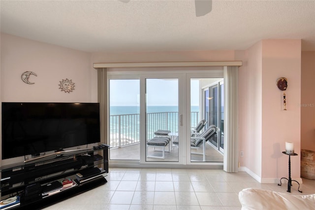 2937 S Atlantic Ave Unit 2001, Daytona Beach, FL 32118 - living area featuring a textured ceiling, a water view, baseboards, and light tile patterned floors