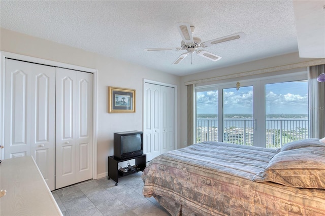 2937 S Atlantic Ave Unit 2001, Daytona Beach, FL 32118 - bedroom featuring two closets, access to exterior, ceiling fan, and a textured ceiling