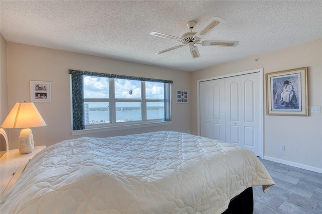 2937 S Atlantic Ave Unit 2001, Daytona Beach, FL 32118 - bedroom featuring a textured ceiling, a closet, baseboards, and a ceiling fan