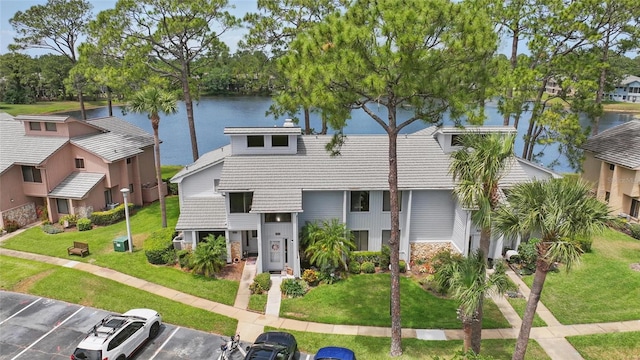 townhome / multi-family property featuring a water view, uncovered parking, and a front yard