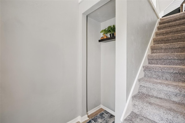 staircase with baseboards and wood finished floors