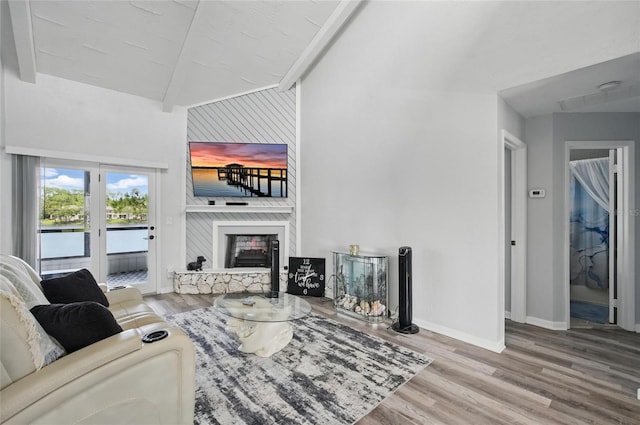 living room featuring baseboards, a large fireplace, wood finished floors, and lofted ceiling