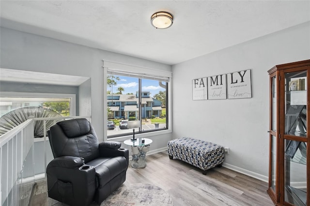 living area featuring baseboards and wood finished floors