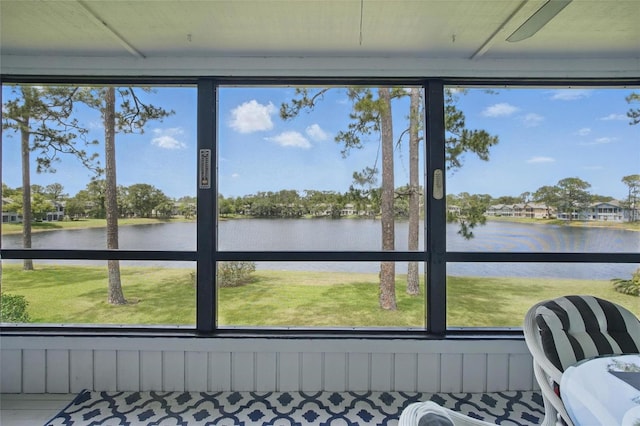 sunroom featuring a water view