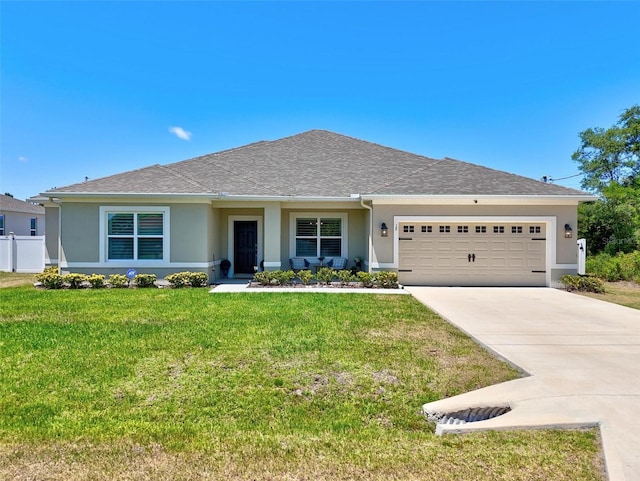 ranch-style home with roof with shingles, an attached garage, driveway, stucco siding, and a front lawn