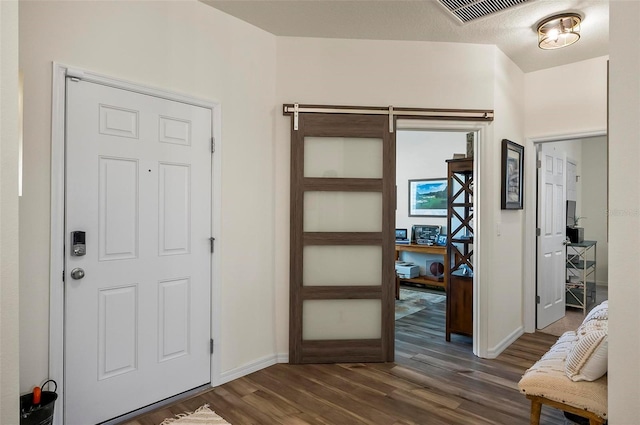 foyer entrance with baseboards, dark wood finished floors, and visible vents