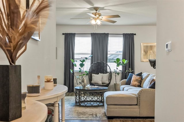 living area featuring a ceiling fan and wood finished floors