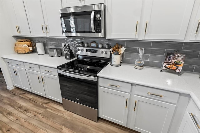 kitchen featuring light countertops, tasteful backsplash, and appliances with stainless steel finishes