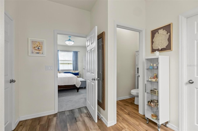 interior space featuring toilet, baseboards, connected bathroom, and wood finished floors