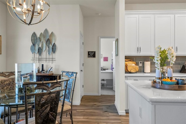 interior space featuring baseboards, an inviting chandelier, and wood finished floors