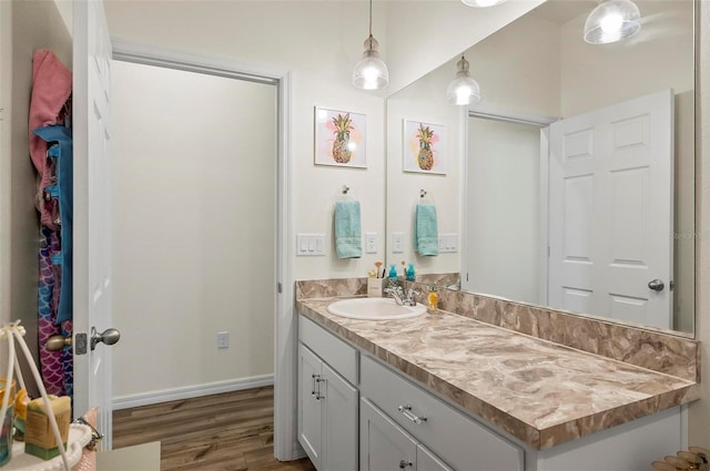 bathroom featuring vanity, baseboards, and wood finished floors