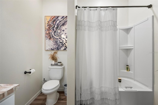 bathroom featuring toilet, shower / bath combo with shower curtain, wood finished floors, vanity, and baseboards