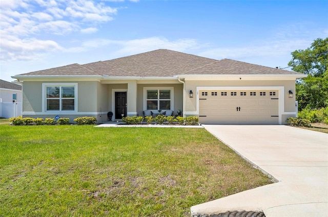 view of front of property featuring concrete driveway, stucco siding, a front yard, and a garage
