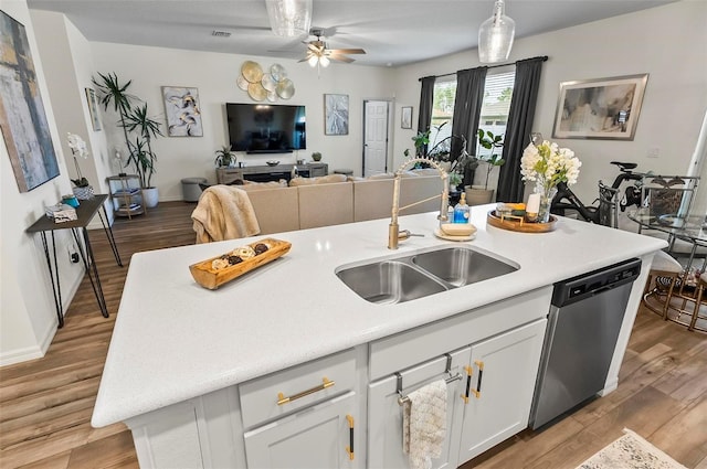 kitchen with dishwasher, ceiling fan, a sink, white cabinetry, and open floor plan