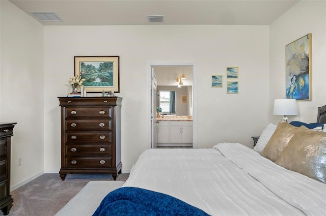 bedroom with baseboards, ensuite bathroom, visible vents, and carpet