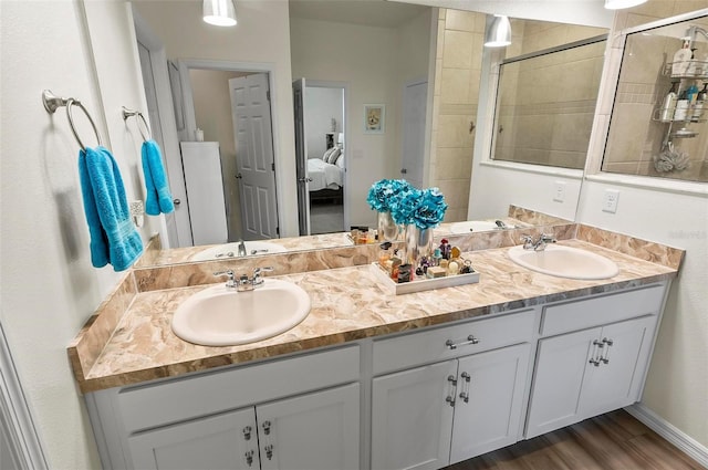 full bathroom with double vanity, ensuite bathroom, a stall shower, and a sink
