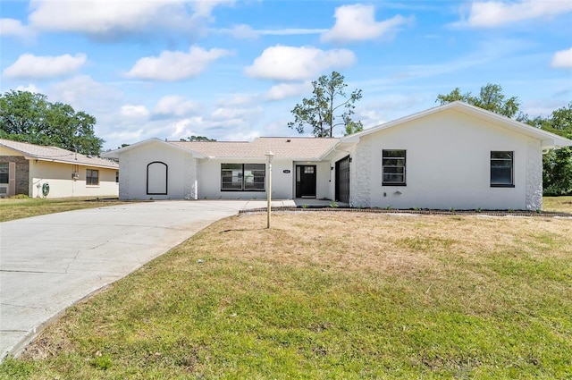 104 Foxhall Ln, Palm Coast, FL 32137 - ranch-style home with concrete driveway, a front lawn, and stucco siding
