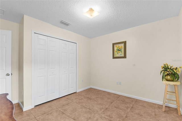 237 N Hidden Tree Dr, Saint Augustine, FL 32086 - unfurnished bedroom featuring a textured ceiling, a closet, and light tile patterned floors