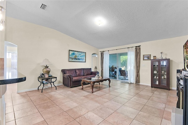 237 N Hidden Tree Dr, Saint Augustine, FL 32086 - living area featuring arched walkways, vaulted ceiling, and a textured ceiling