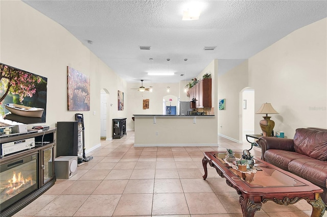 237 N Hidden Tree Dr, Saint Augustine, FL 32086 - living area featuring arched walkways, light tile patterned flooring, a textured ceiling, and a ceiling fan