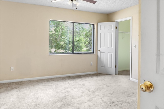 14 Post Oak Ln, Palm Coast, FL 32164 - unfurnished bedroom with carpet floors, baseboards, a textured ceiling, a spacious closet, and ceiling fan