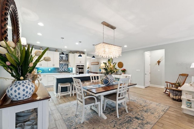 dining room featuring a chandelier, recessed lighting, ornamental molding, baseboards, and light wood-style floors